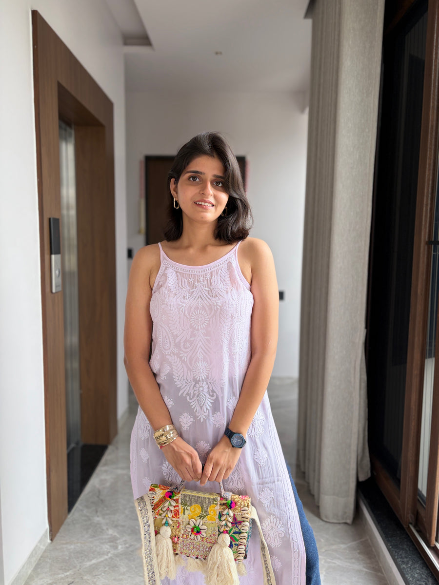 Blush pink viscose noodle strap chikankari kurta - woman standing in hallway holding embellished potli bag